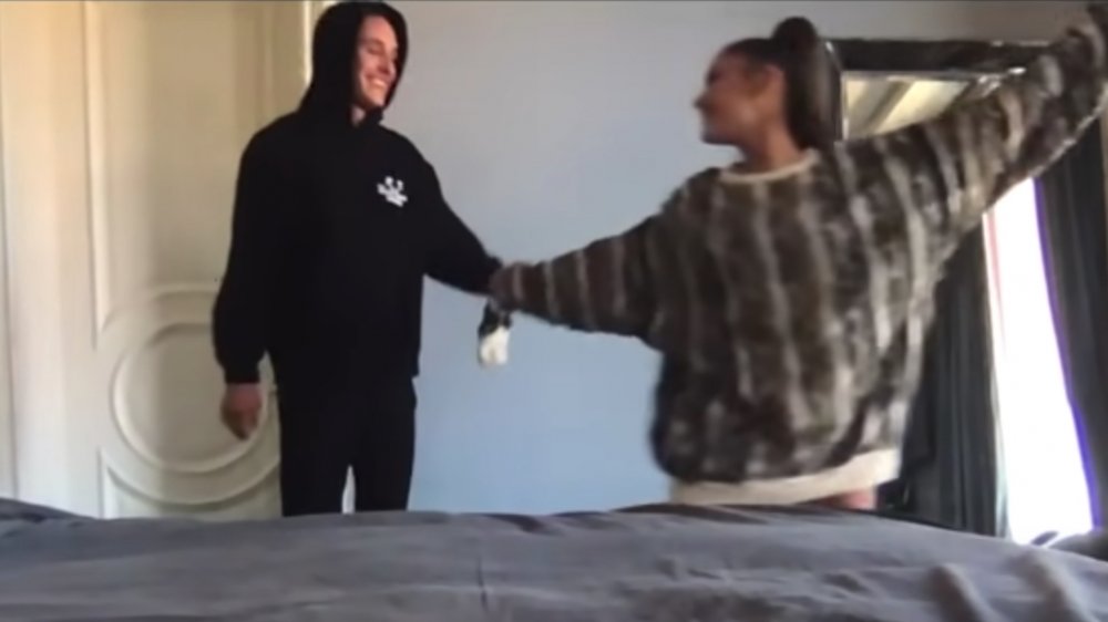 Dalton Gomez e Ariana Grande mano nella mano in piedi in una camera da letto