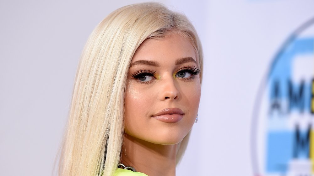 Loren Gray in abito giallo, guardando oltre la spalla