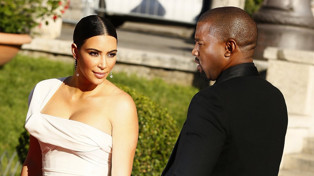 Kim Kardashian in abito bianco e Kanye West a un evento sul red carpet