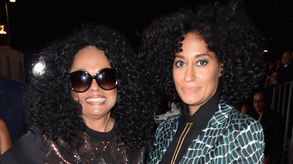 Diana Ross sorridente in abito nero e occhiali da sole, Tracee Ellis Ross con una seria espressione in un blazer verde e nero