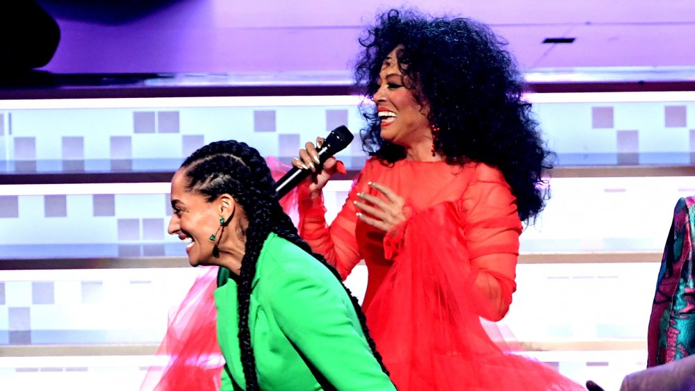 Tracee Ellis Ross in abito verde, Diana Ross in abito rosso, entrambe ridendo sul palco ai Grammy 2019