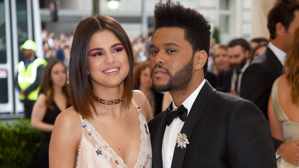 Selena Gomez in abito bianco, The Weeknd in abito nero