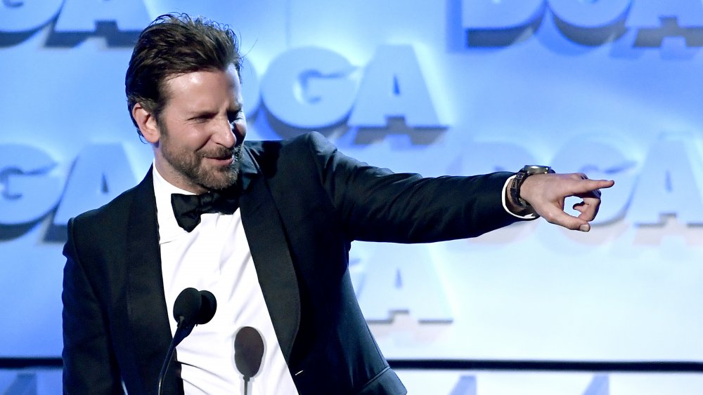 Bradley Cooper punta fuori dal palco durante un'apparizione premio 