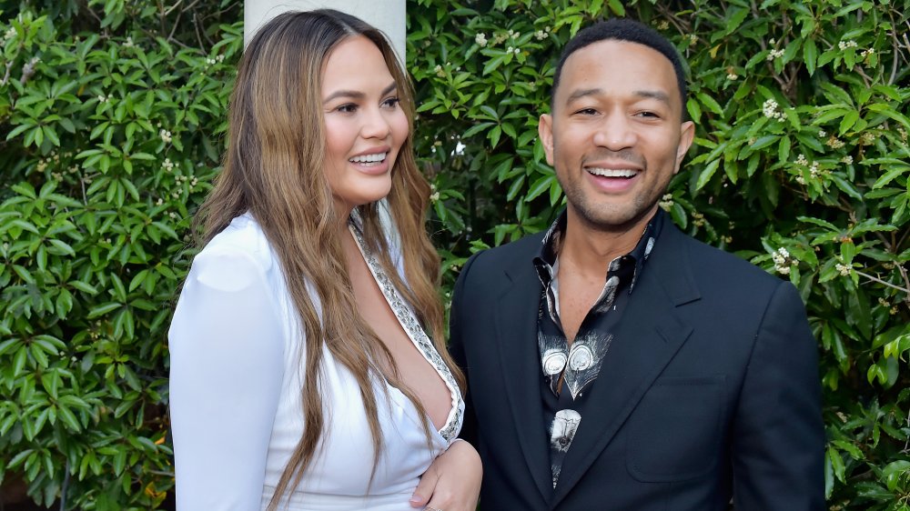 Chrissy Teigen e John Legend di fronte al verde 