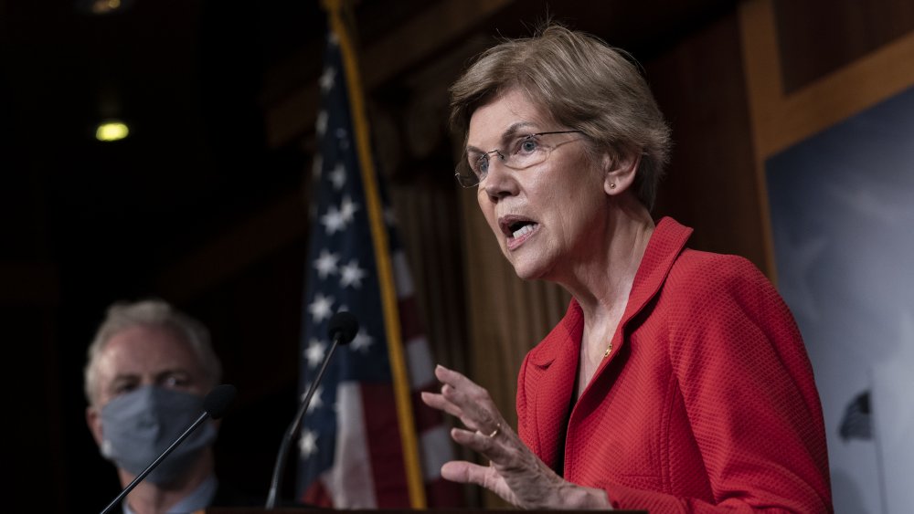 Elizabeth Warren in un blazer rosso, parlando durante un evento politico