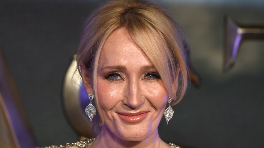 J.K. Rowling in un abito scintillante d'oro, sorridente con i capelli in su