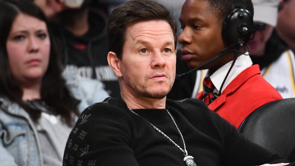 Mark Wahlberg in camicia nera, seduto