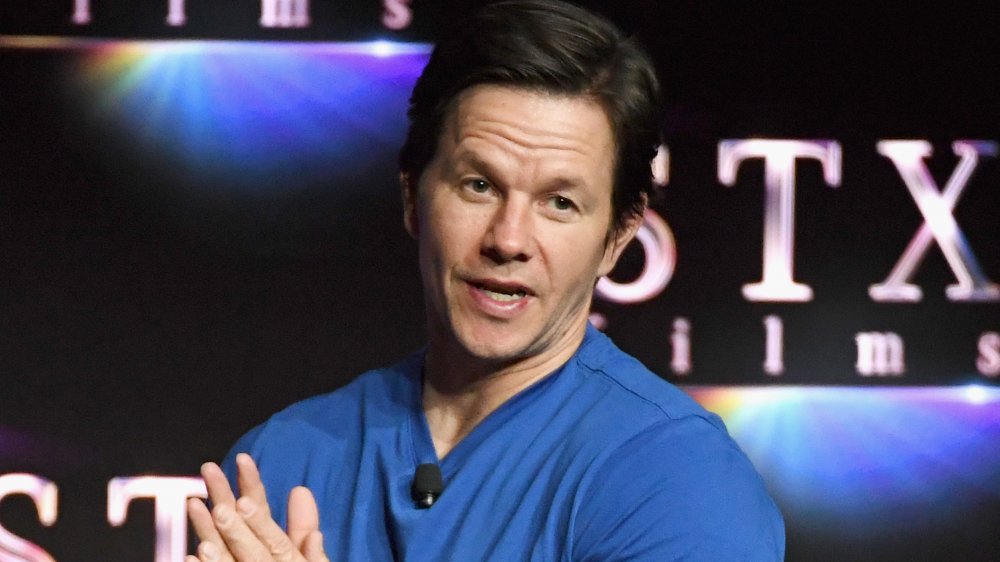 Mark Wahlberg in camicia blu, parlando a una folla