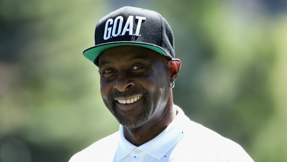 Jerry Rice sorridente in una polo bianca e cappello nero GOAT