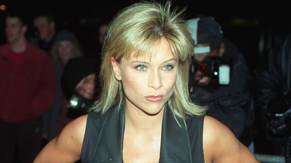 Samantha Fox in abito nero, in posa con un sorriso mentre è circondata da fotografi a metà degli anni '90