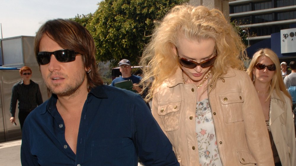 Keith Urban sembra serio, Nicole Kidman guardando verso il basso, entrambi con gli occhiali da sole