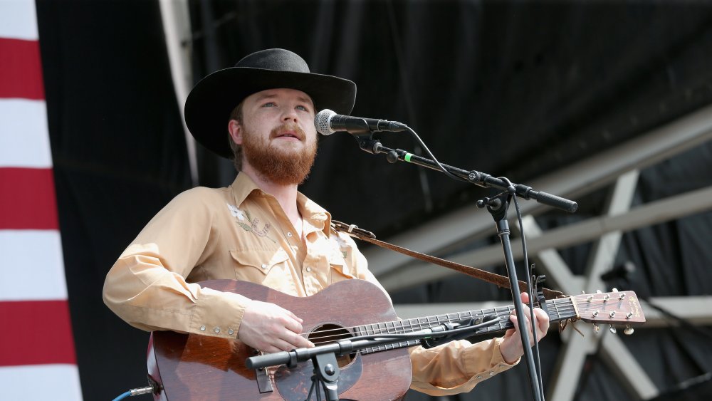 Colter Wall in cappello da cowboy e chitarra sul palco