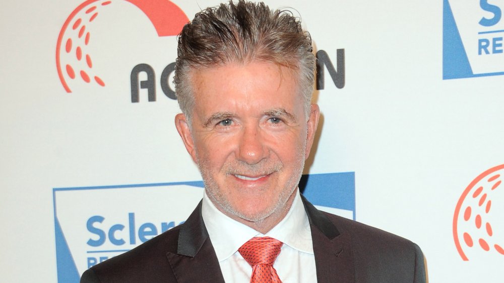 Alan Thicke sorride in giacca e cravatta rossa