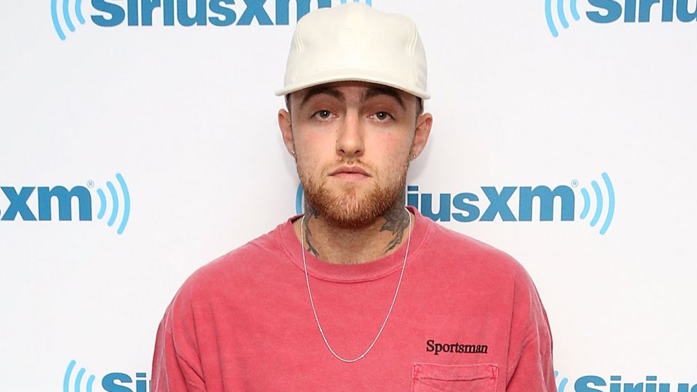 Mac Miller in una maglietta rosa e berretto da baseball bianco