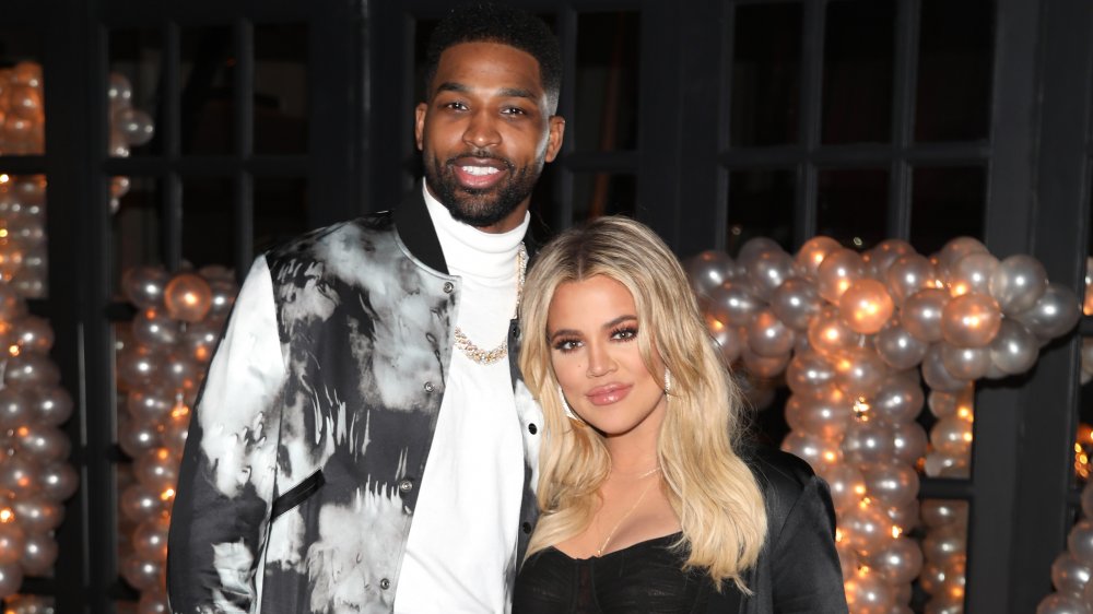 Tristan Thompson e Khloe Kardashian sorridenti insieme davanti a un mazzo di palloncini