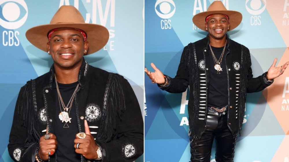 Jimmie Allen in marrone cappello a tesa larga e ensemble nero