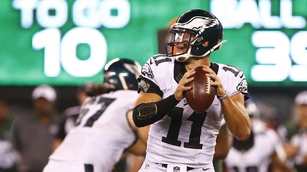 Tim Tebow in su per lanciare un pallone da calcio in uniforme Philadelphia Eagles