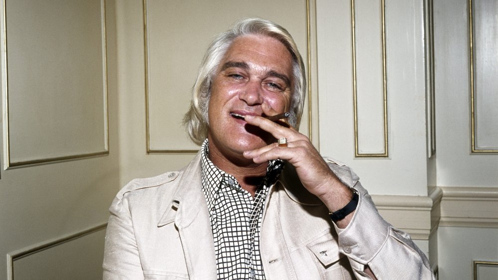 Charlie Rich seduto, sorridente e fumante