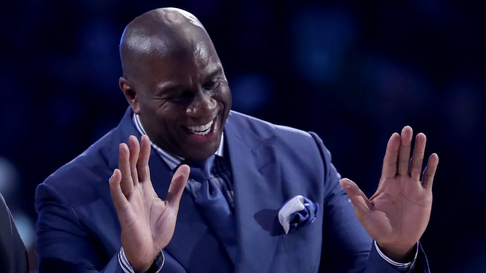 Magic Johnson con le mani in alto, ridendo