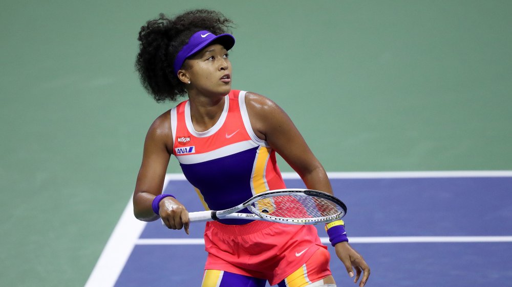 Naomi Osaka sul campo da tennis, giocando