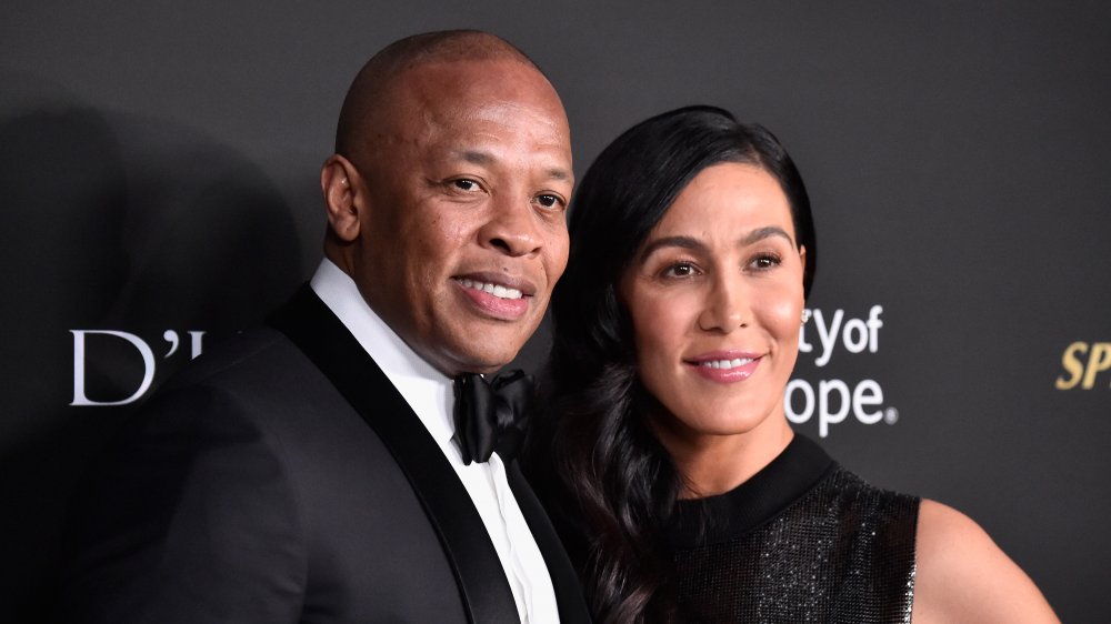 Dr. Dre e Nicole Young, in posa braccio-in-braccio e sorridente sul tappeto rosso