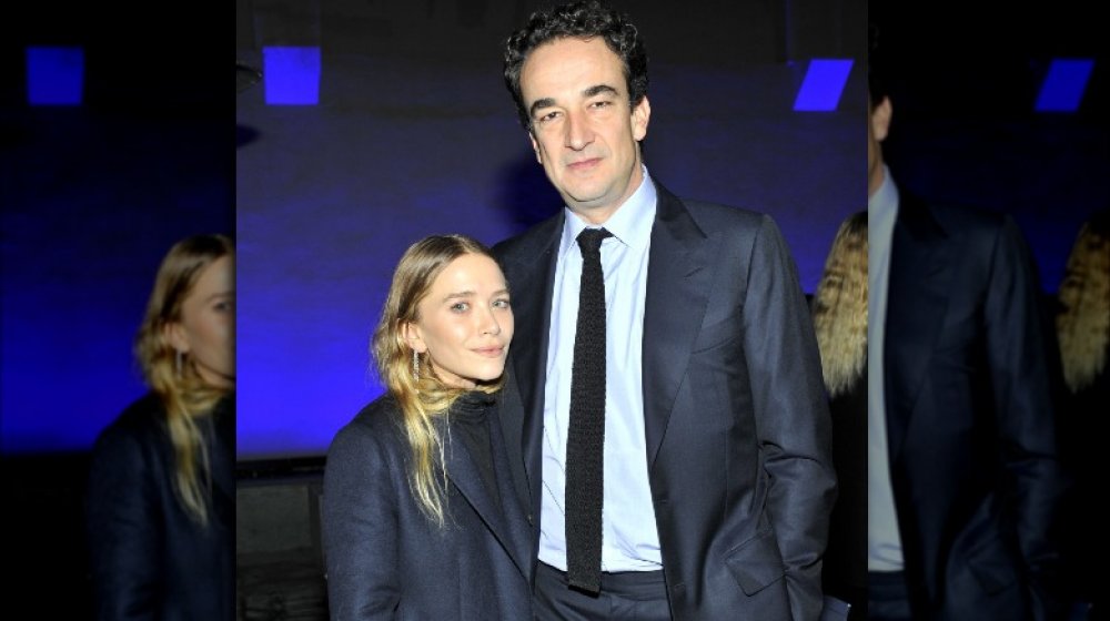 Mary-Kate Olsen e Pierre Olivier Sarkozy, in posa braccio a braccio con espressioni serie