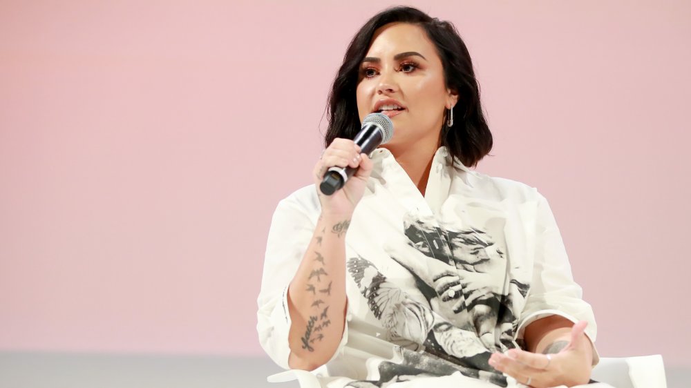 Demi Lovato a un pannello, microfono in mano, parlando