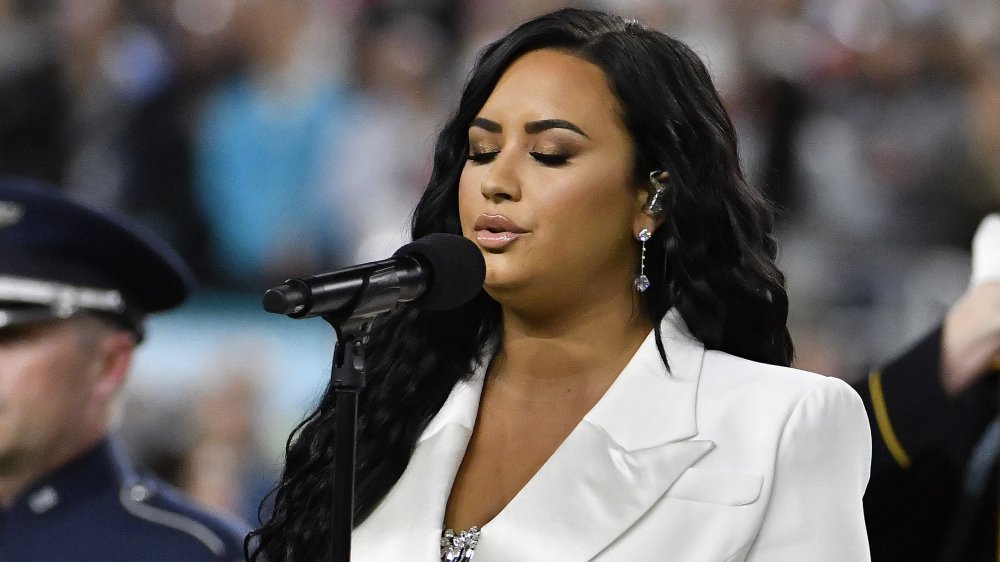 Demi Lovato sul palco, canta in un blazer bianco