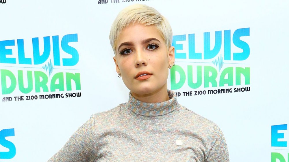 Halsey con i capelli biondi corti e il top grigio mock-neck