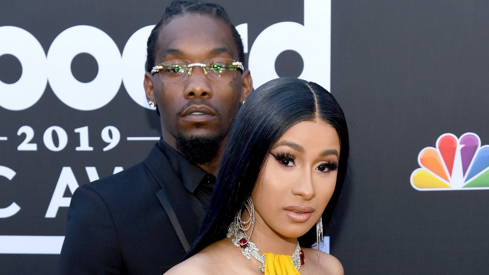 Offset in piedi dietro Cardi B con le braccia intorno a lei 