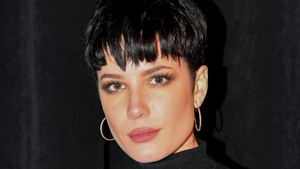 Halsey con capelli neri corti e orecchini