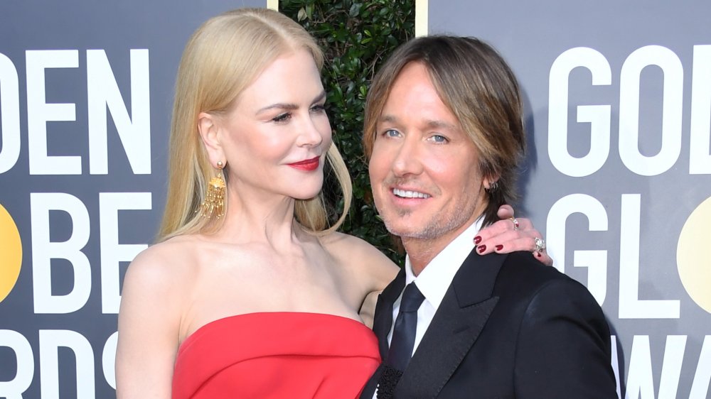 Nicole Kidman in abito rosso con il braccio intorno alla spalla di Keith Urban