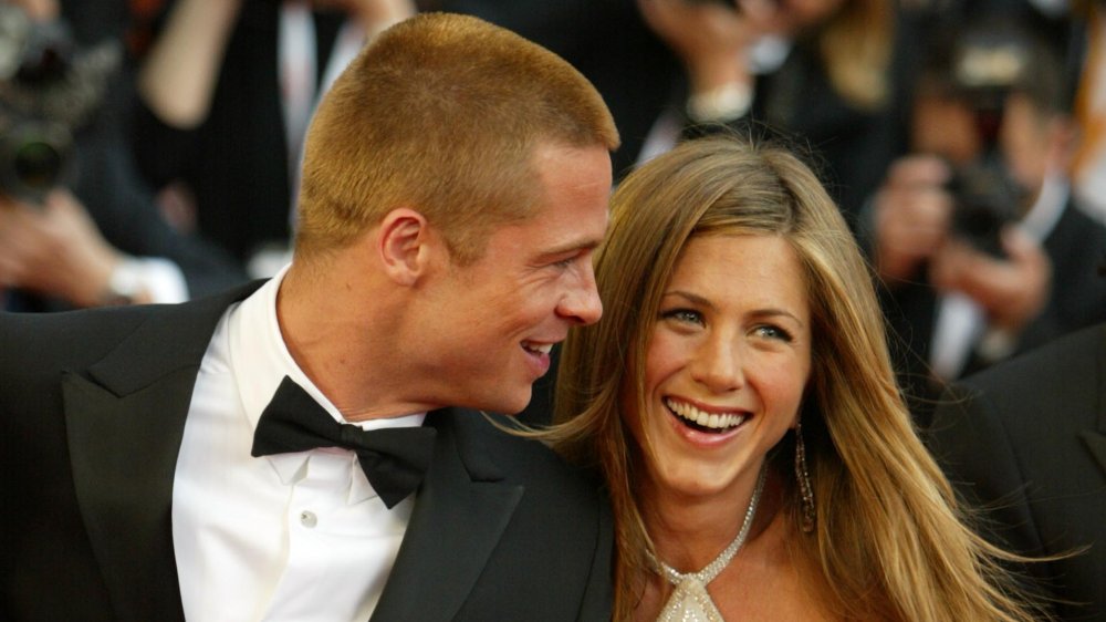 Brad Pitt e Jennifer Aniston si tengono per mano e ridono alla prima di Troy nel 2004