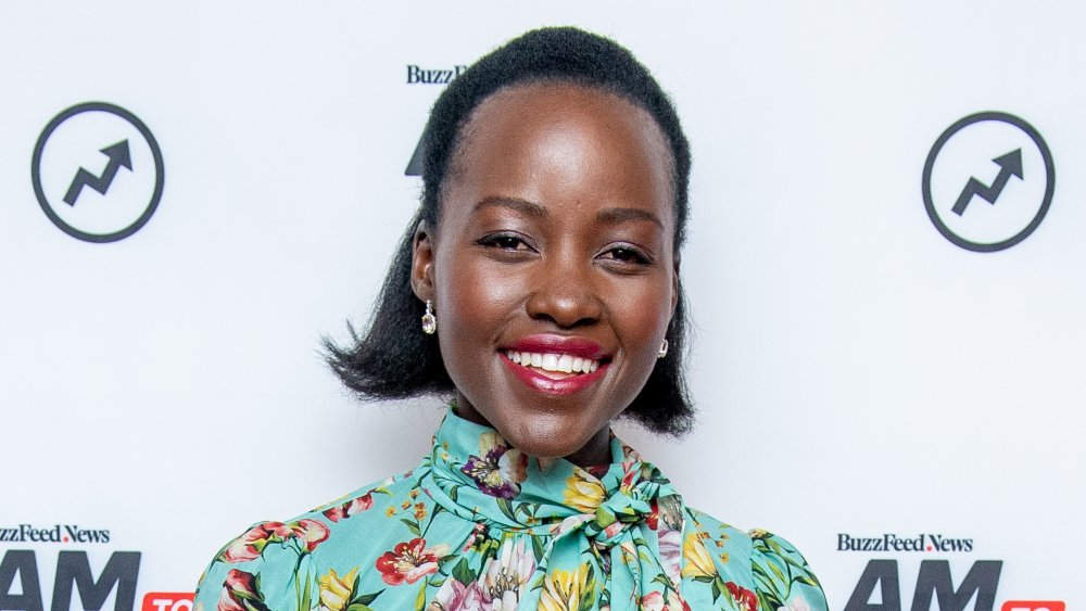 Lupita Nyong'o smiling in a floral dress