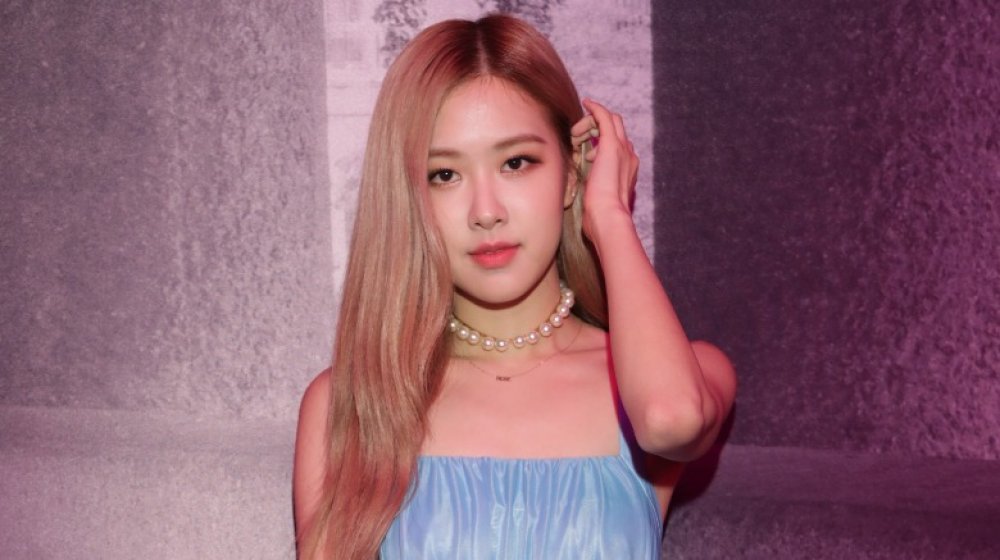 Rosé di BLACKPINK posa con un piccolo sorriso mentre si aggiusta i capelli