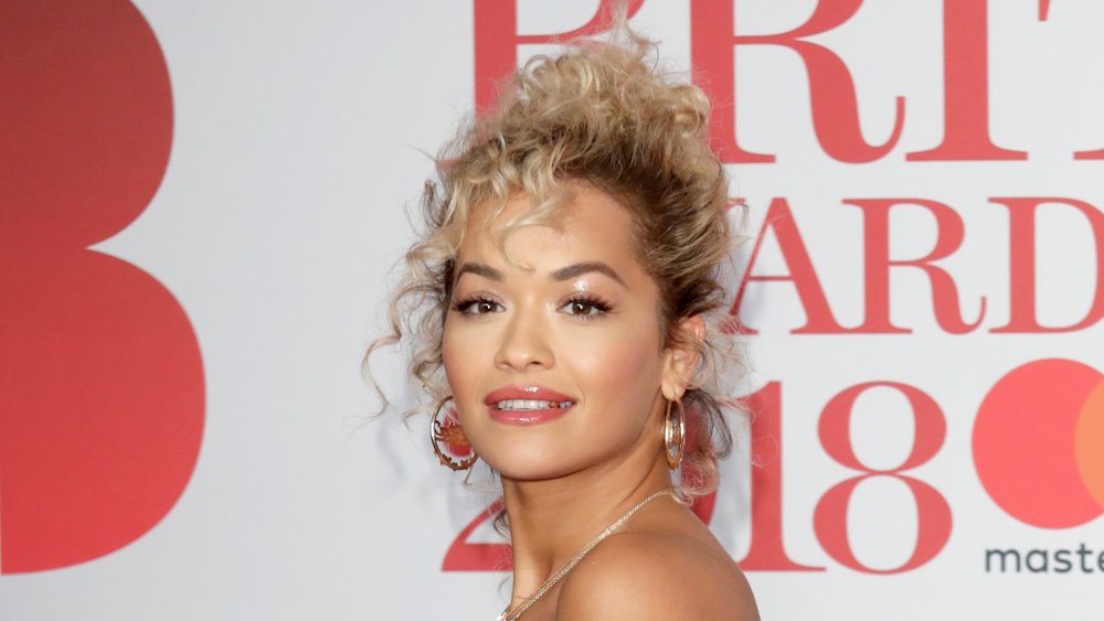 Rita Ora con i capelli raccolti e orecchini d'oro