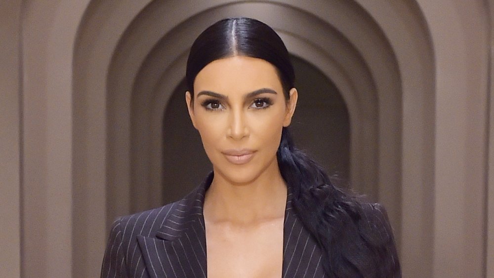 Kim Kardashian con i capelli in cavallino basso e un blazer nero