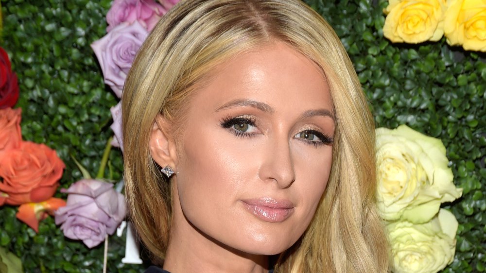 Paris Hilton davanti al muro di fiori