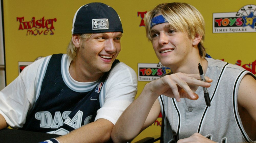 Nick Carter e Aaron Carter scherzano mentre firmano autografi 