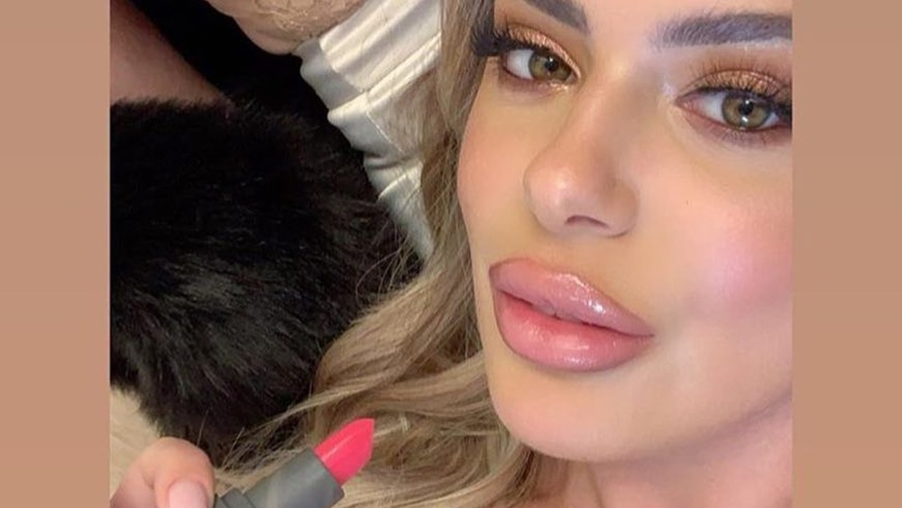 Brielle Biermann tiene in mano un rossetto della sua linea di makeup