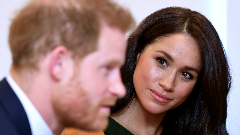 Meghan Markle guarda il principe Harry durante un evento