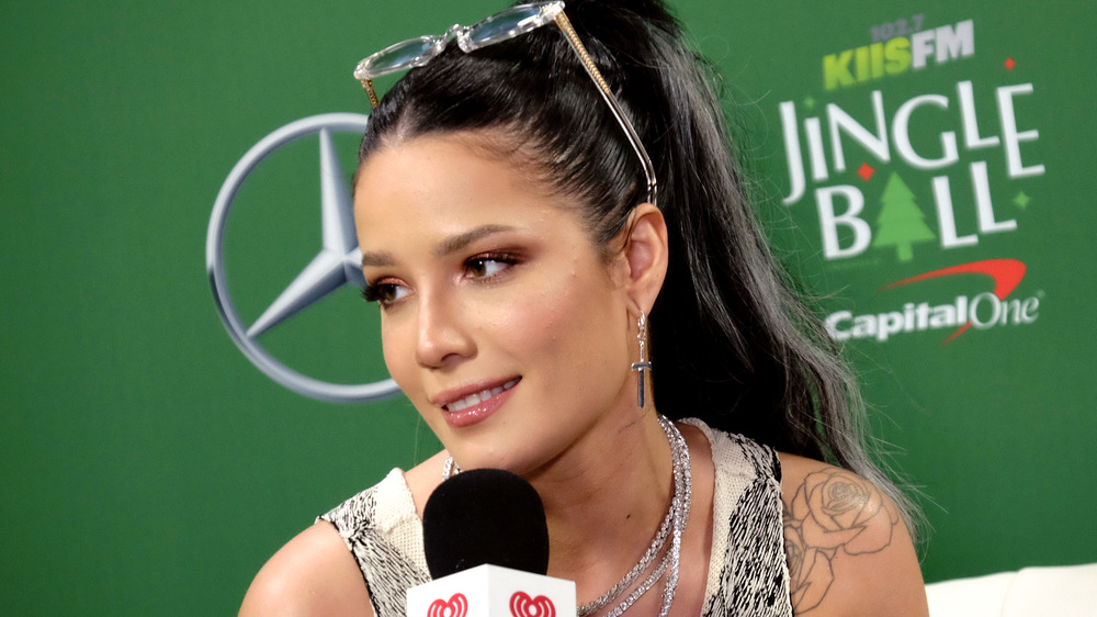 Halsey sorride e tiene in mano un microfono al Jingle Ball nel 2019