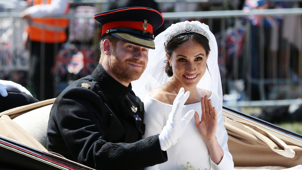 Il principe Harry e Meghan Markle sorridono e salutano i fan il giorno del loro matrimonio 