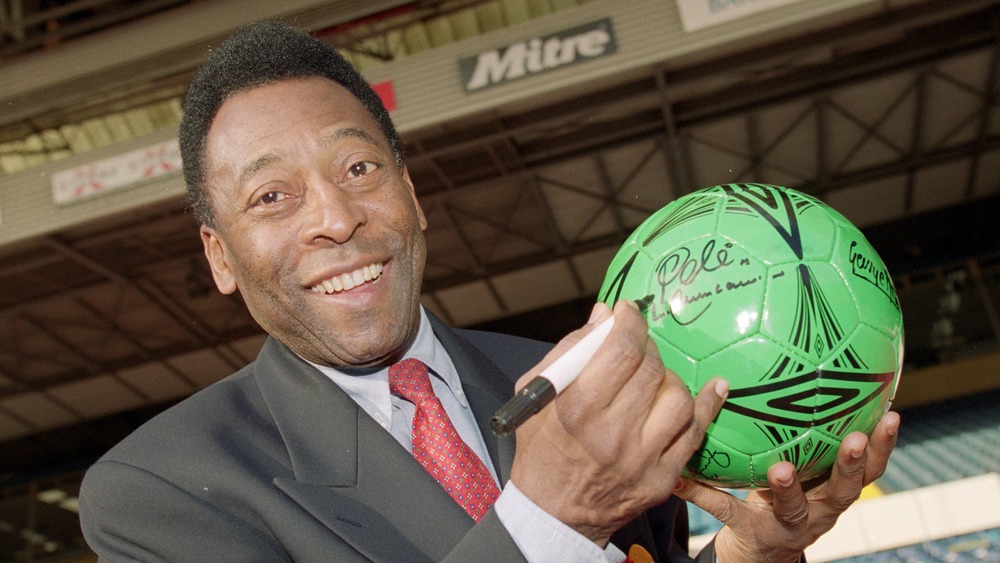 Pele firma autografo su un pallone da calcio