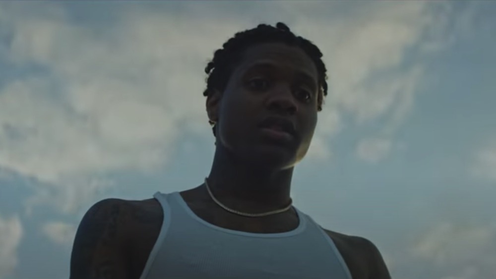 Lil Durk guarda in basso, nuvole sopra di lui