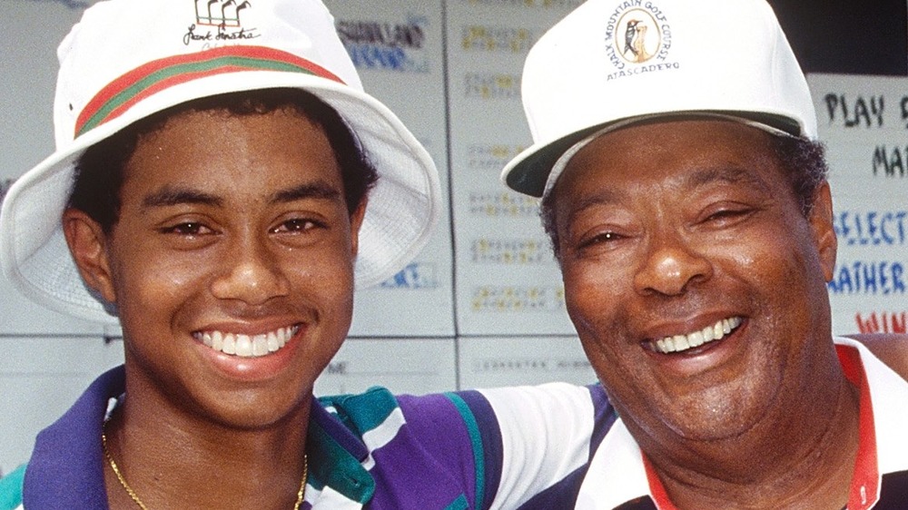 Il giovane Tiger Woods con il braccio intorno a suo padre Earl Woods