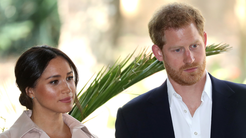 Il principe Harry e Meghan Markle con espressioni serie