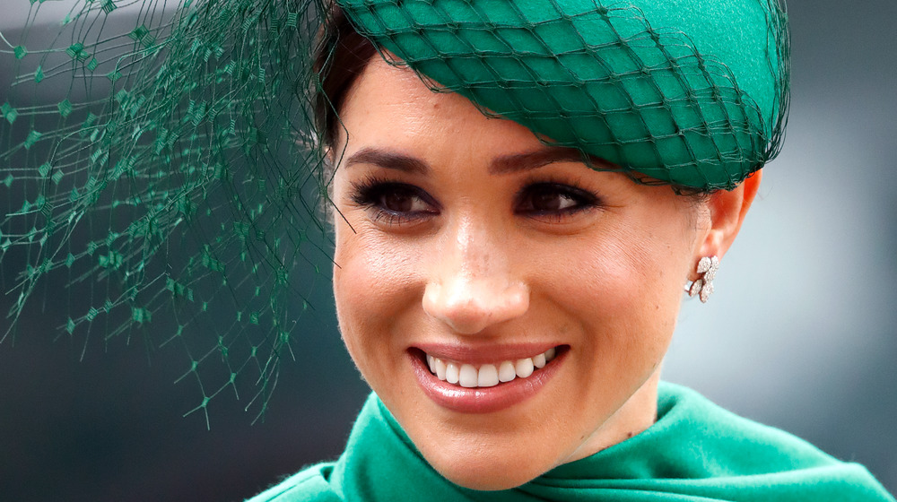 La duchessa Meghan Markle sorride con un cappello verde