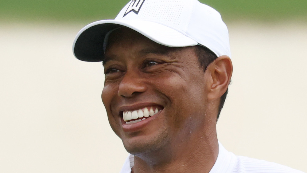 Tiger Woods sorride su un campo da golf nel 2020