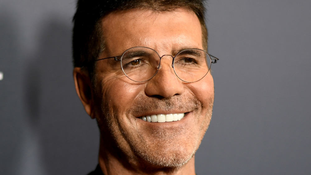 Simon Cowell sorride con gli occhiali